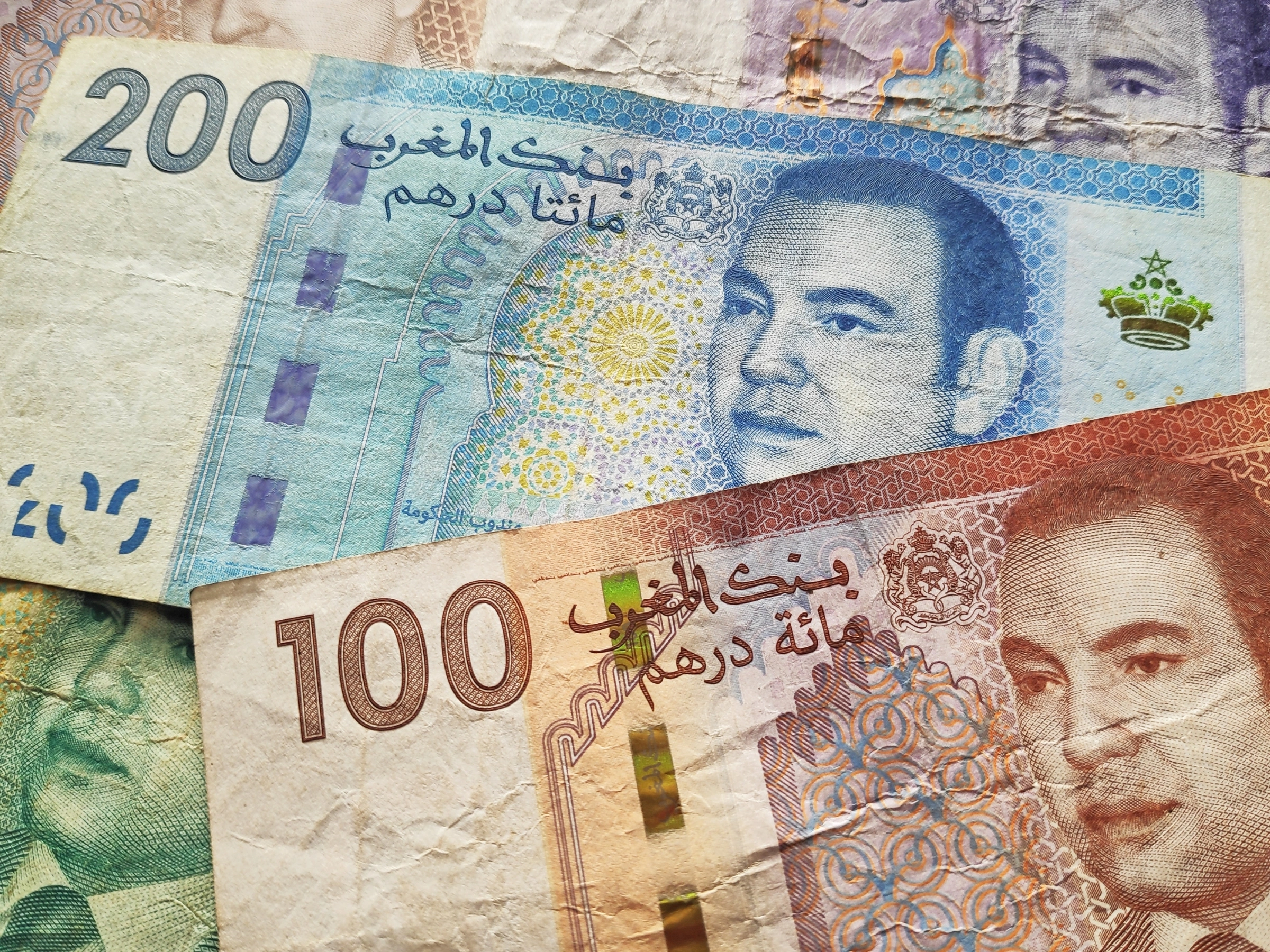 Se extienden múltiples billetes de dirham de Emiratos Árabes Unidos de diversas denominaciones, con intrincados diseños y características holográficas.